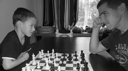 Young Moses Finlay playing chess with his dad.